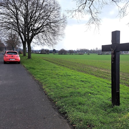 Am Rande des bislang landwirtschaftlich genutzten Areals unterhalb des Südfriedhofs, auf dem ein Wohnheim für Geflüchtete entstehen könnte, steht ein großes Kruzifix.
