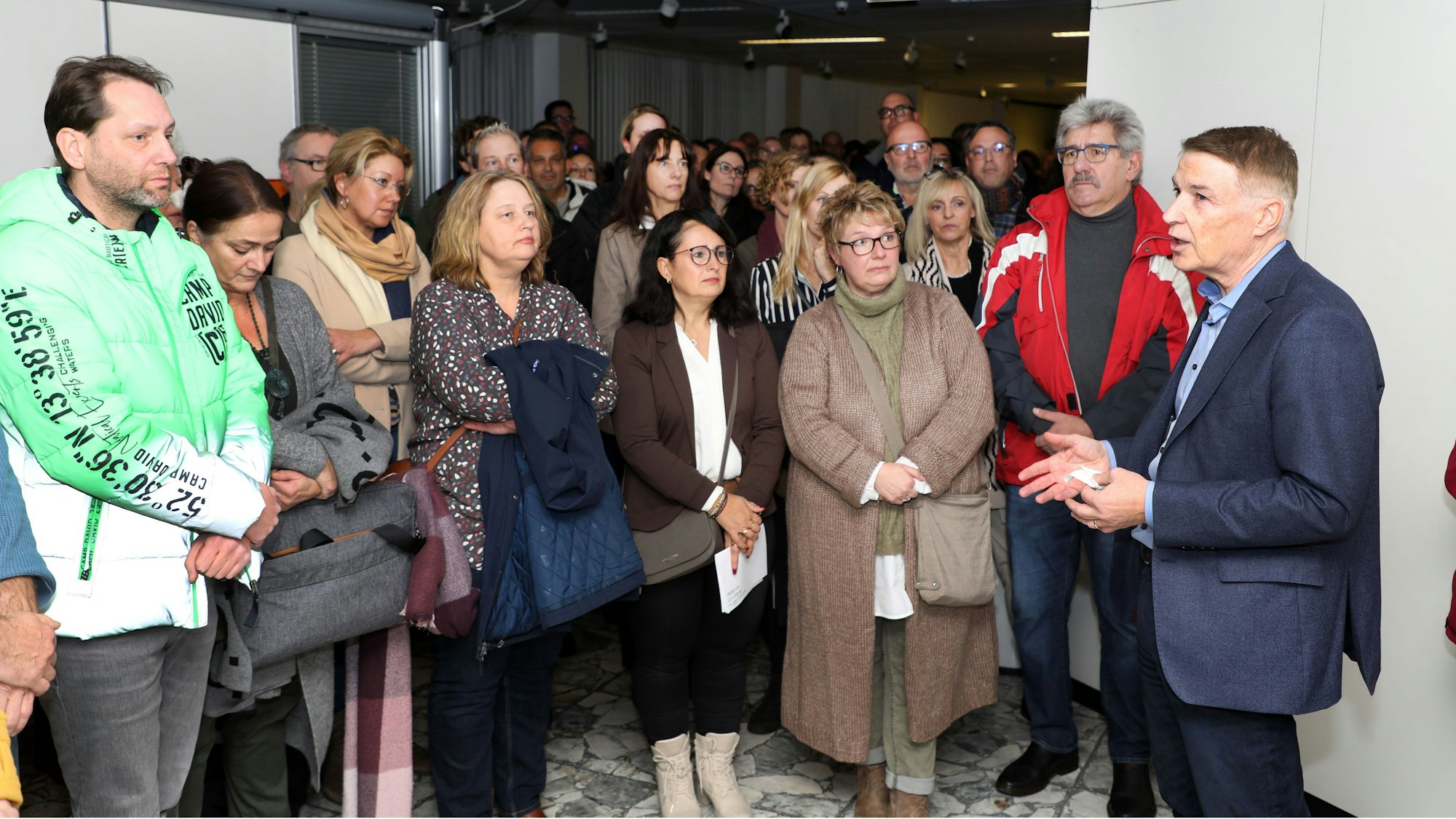 Kreisdirektor Dr. Erik Werdel steht nach der abgewendeten Abschaffung seines Amtes durch die schwarz.-grüne Kreistagsmehrheit im Kreise seiner Unterstützer vor dem Sitzungssaal des Kreishauses Am Rübezahlwald.