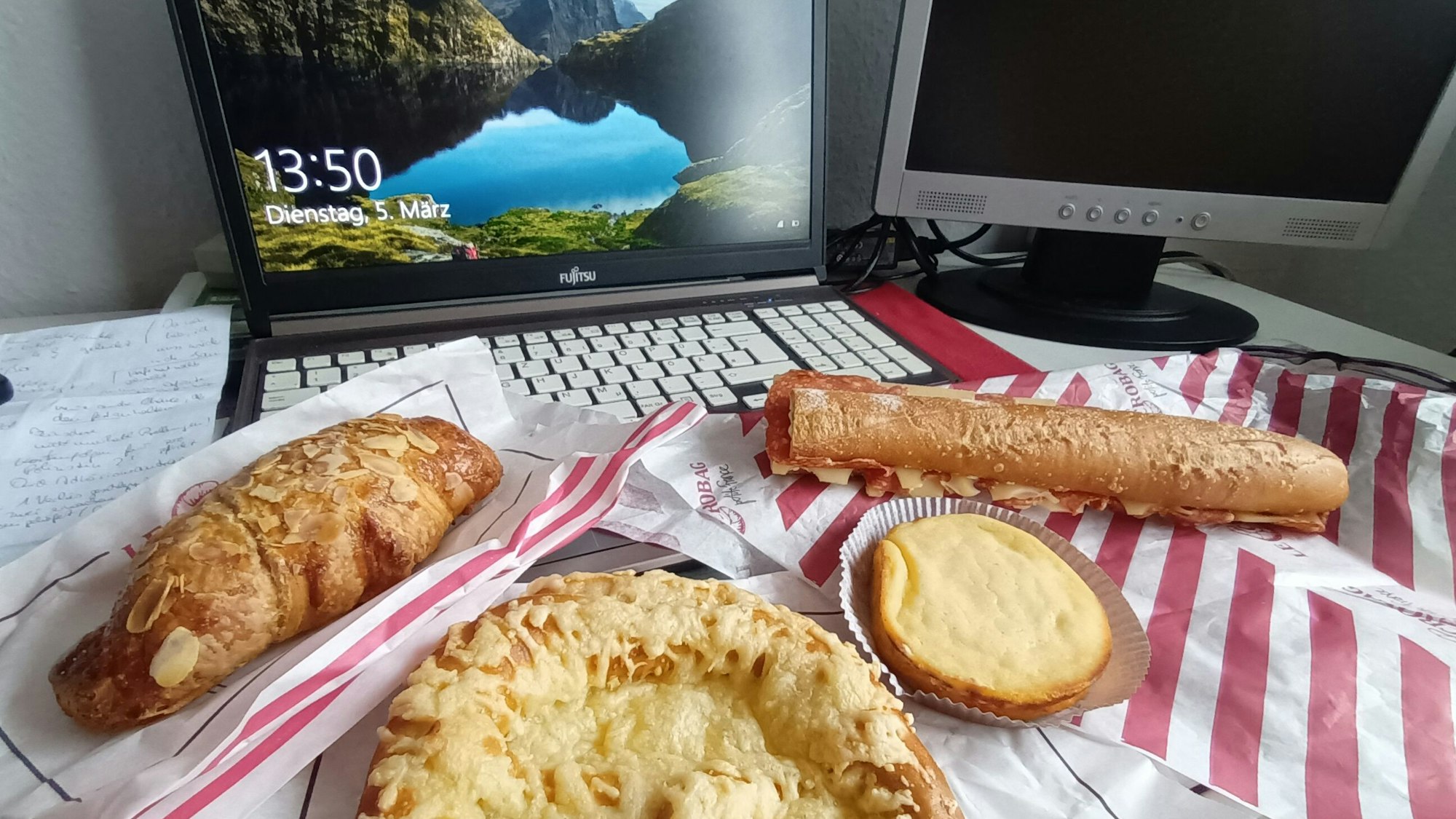 Backwaren liegen vor einem aufgeklappten Laptop