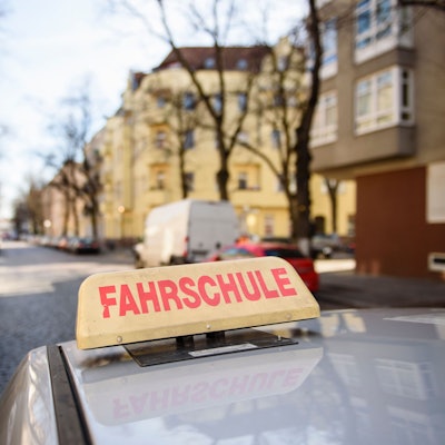 Ein Schild mit der Aufschrift «Fahrschule» ist auf dem Dach eines Fahrschulwagens montiert.