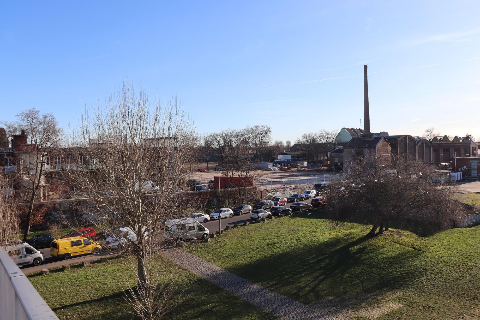 Blick auf eine Rasenfläche und angrenzendes Fabrik-Areal