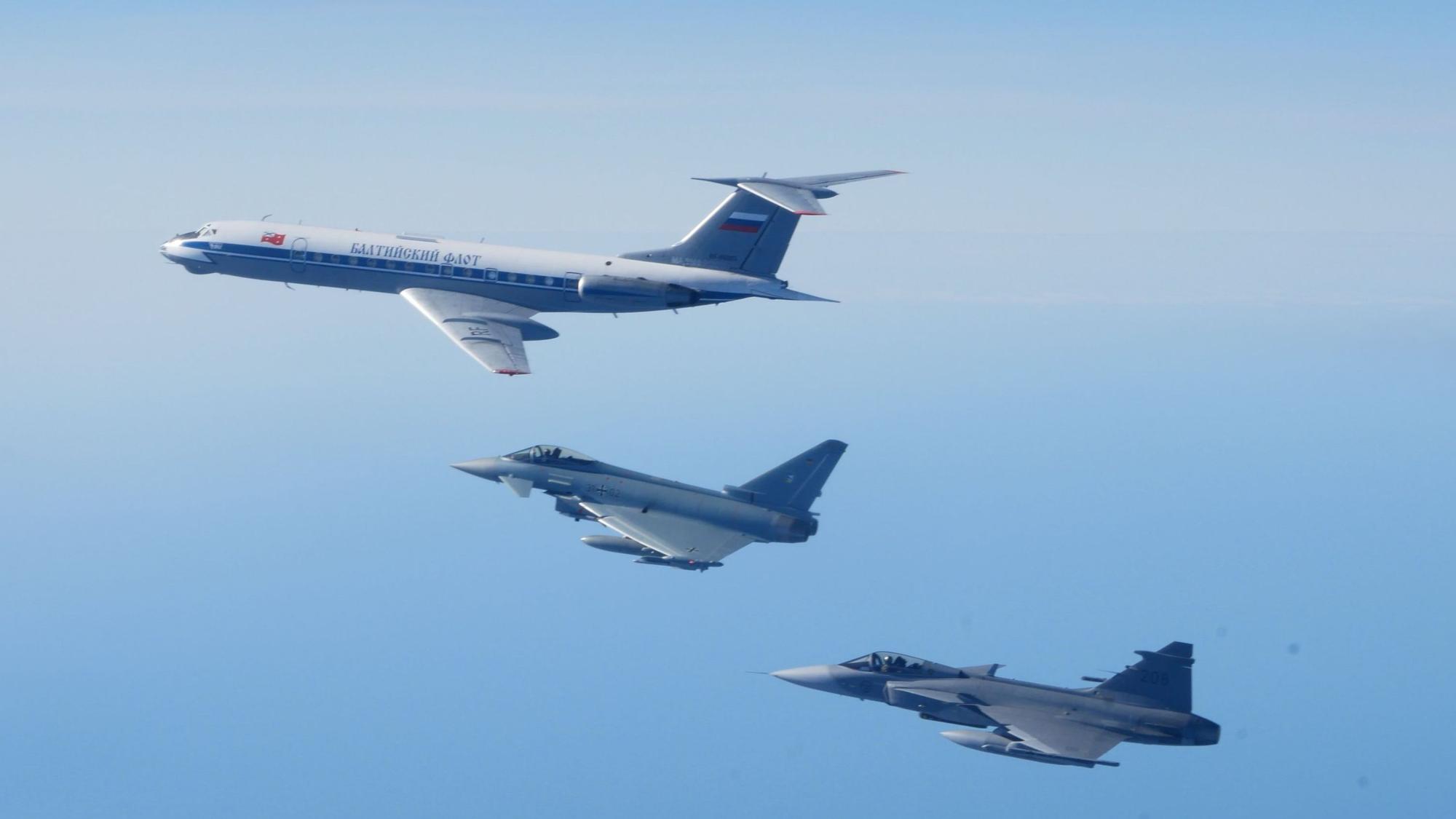 Ein Eurofighter der deutschen Luftwaffe fängt gemeinsam mit einem schwedischen Kampfjet vom Typ Gripen ein russisches Militärflugzeug vom Typ Tupolew TU-134 ab.