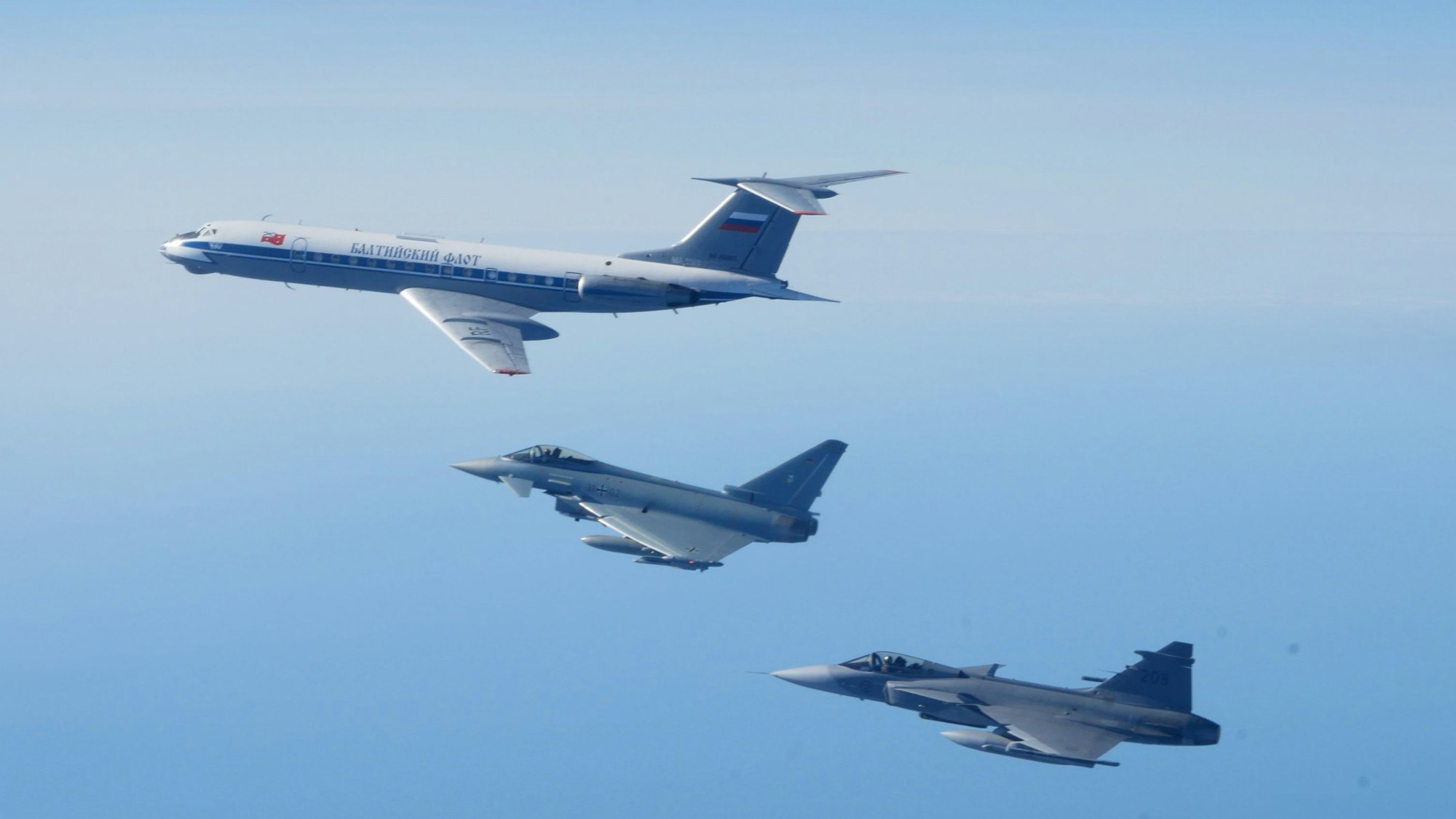 Ein Eurofighter der deutschen Luftwaffe fängt gemeinsam mit einem schwedischen Kampfjet vom Typ Gripen ein russisches Militärflugzeug vom Typ Tupolew TU-134 ab.