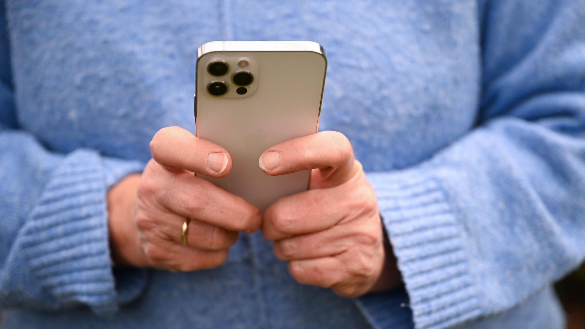 Eine Frau tippt auf ihrem Smartphone.