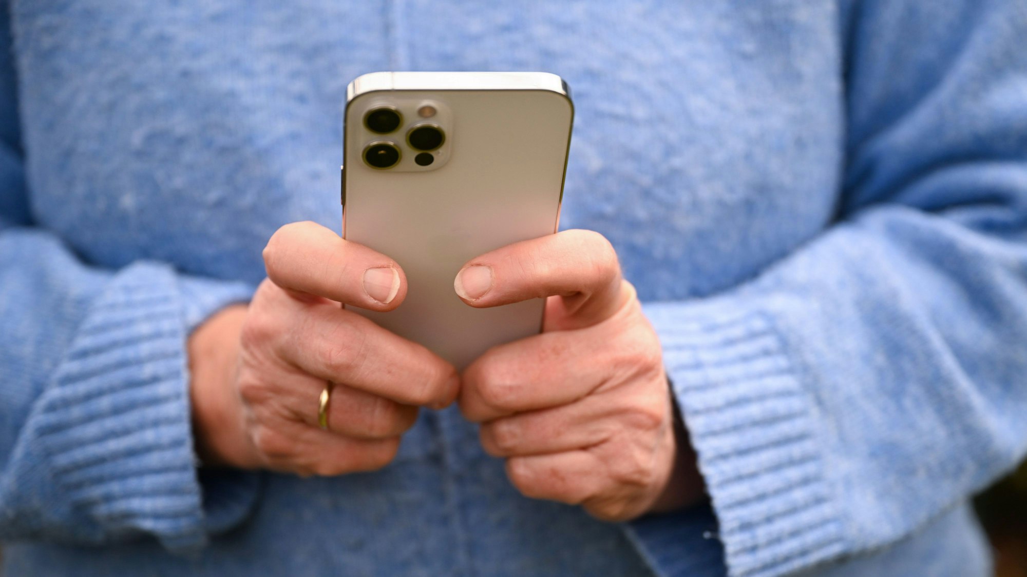 Eine Frau tippt auf ihrem Smartphone.