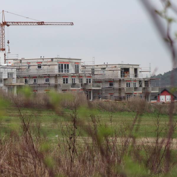 Das Bild zeigt drei im Bau befindliche Mehrfamilienhäuser.