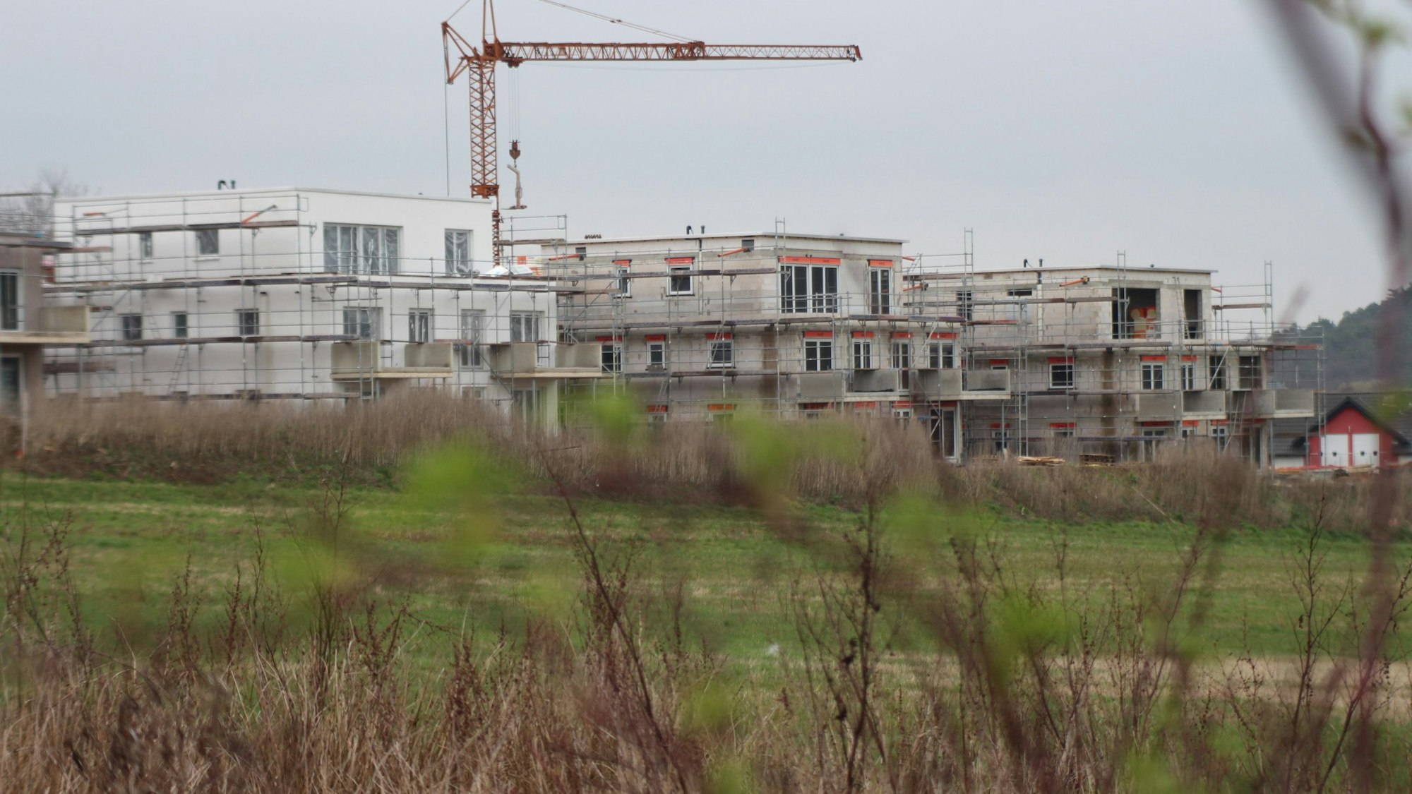 Das Bild zeigt drei im Bau befindliche Mehrfamilienhäuser.