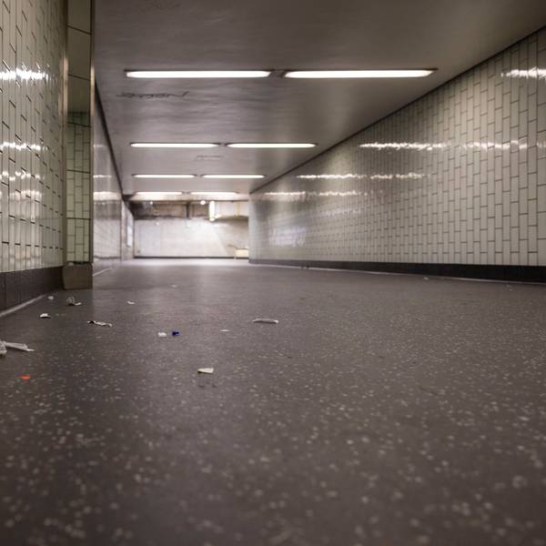 In einem Gang, der zum Bahnsteig führt, liegt Müll auf dem Boden.