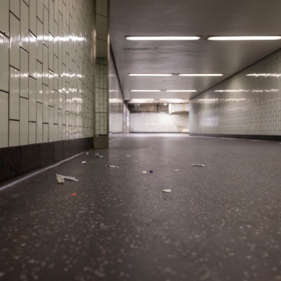 In einem Gang, der zum Bahnsteig führt, liegt Müll auf dem Boden.