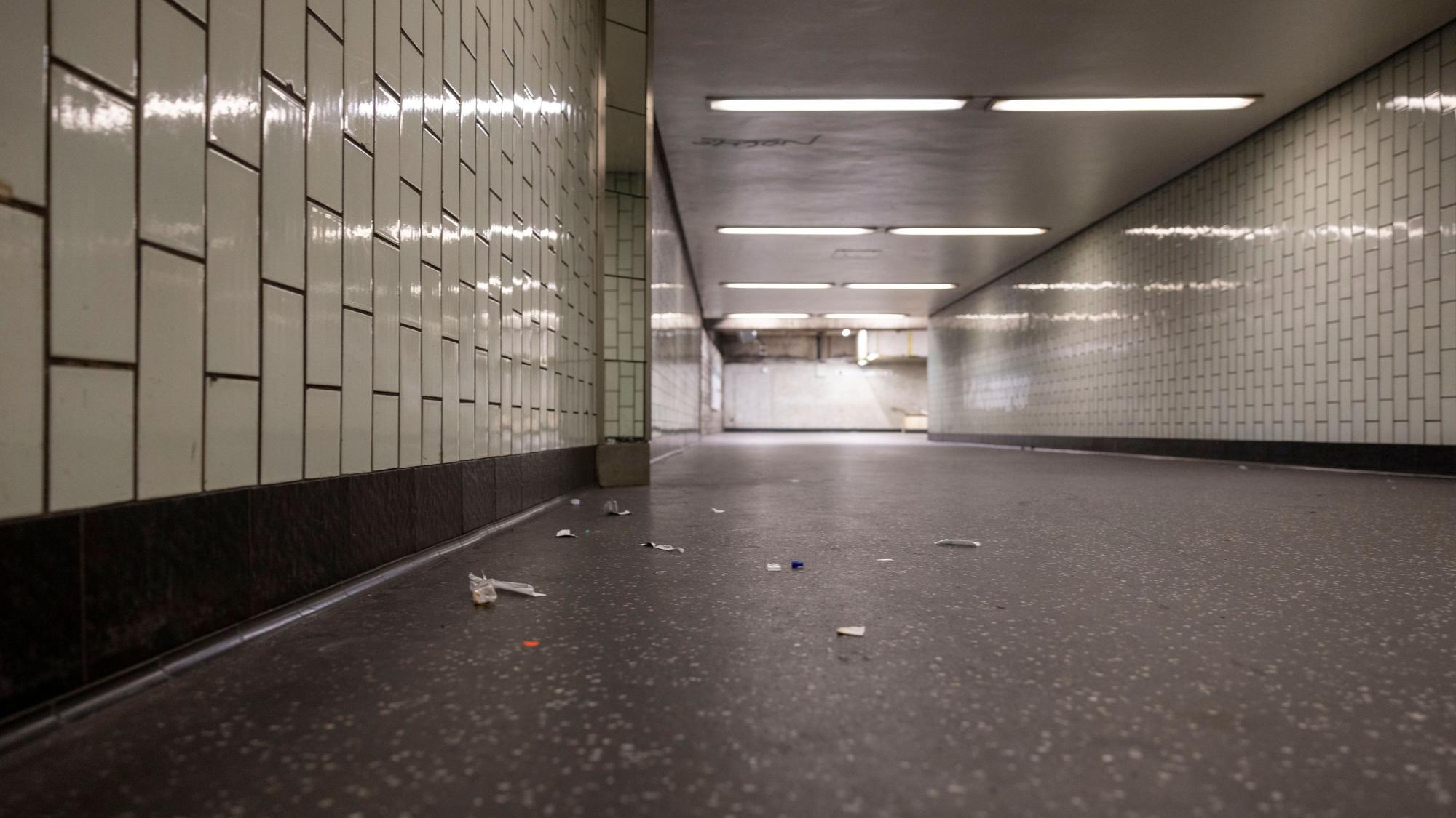 In einem Gang, der zum Bahnsteig führt, liegt Müll auf dem Boden.