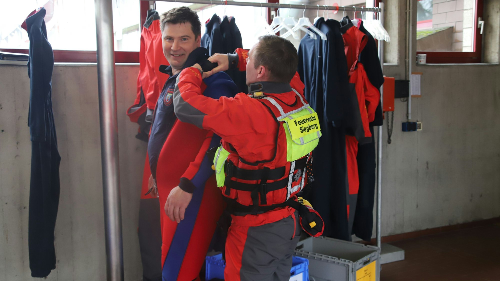Kameraden helfen sich beim An- uns Auskleiden der Trockentauchanzüge.