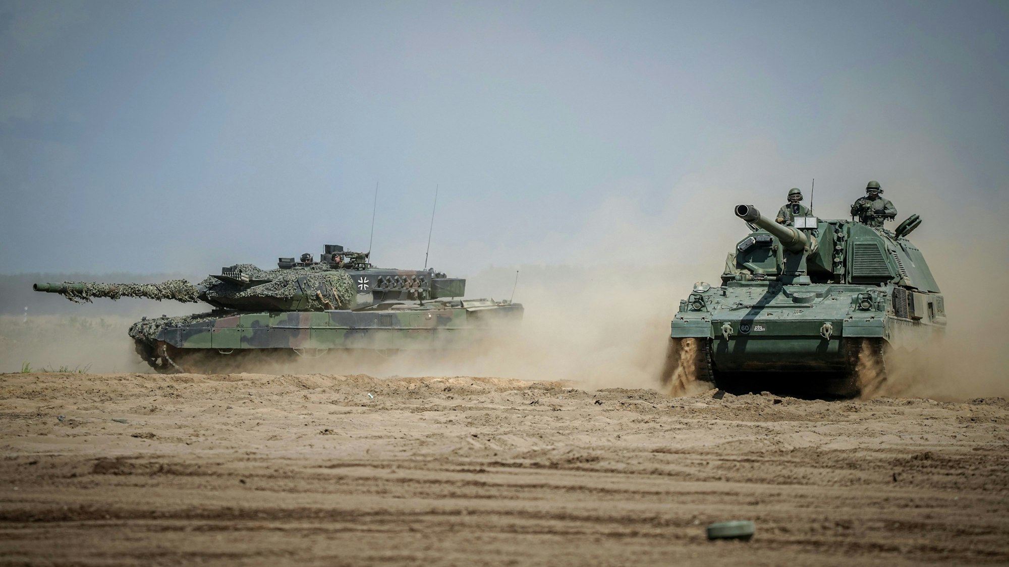 Eine Panzerhaubitze 2000 (r) und ein Leopard 2 Kampfpanzer sind bei der Nato-Übung im Einsatz. (Symbolbild)