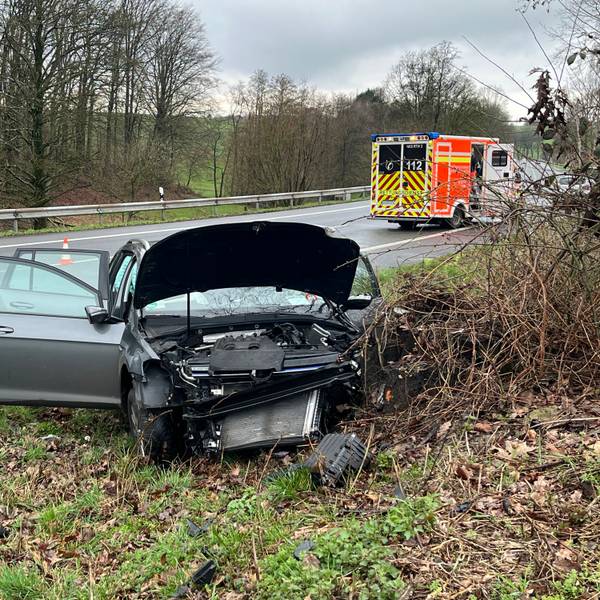 Ein zerstörtes Auto steht neben einer Straße.