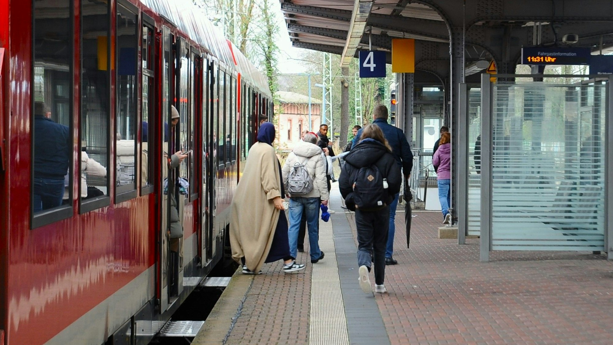 Zu sehen sind Menschen, die aus einem Zug aussteigen.