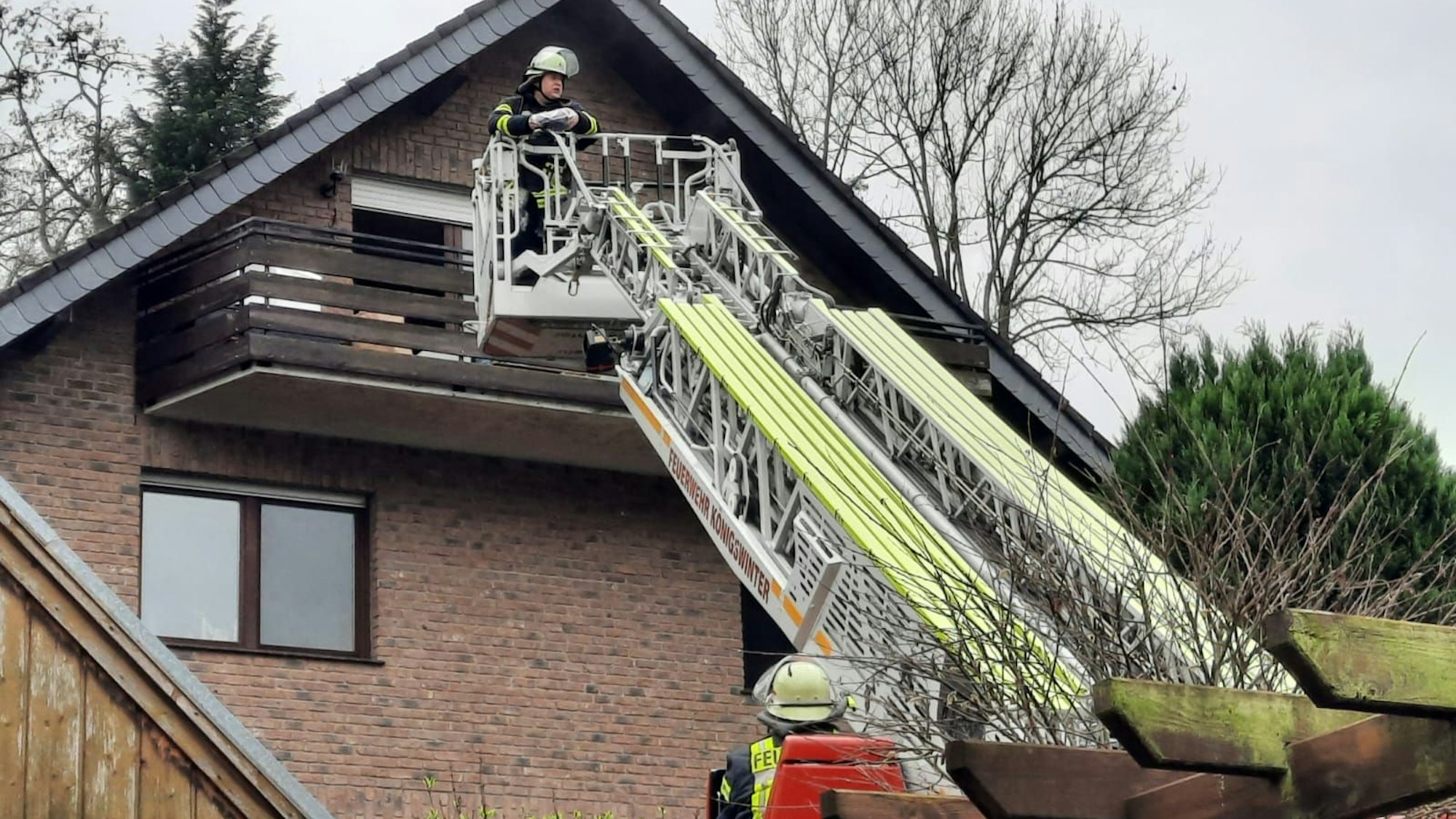 Die Drehleiter der Feuerwehr ist vor einem Haus ausgefahren.