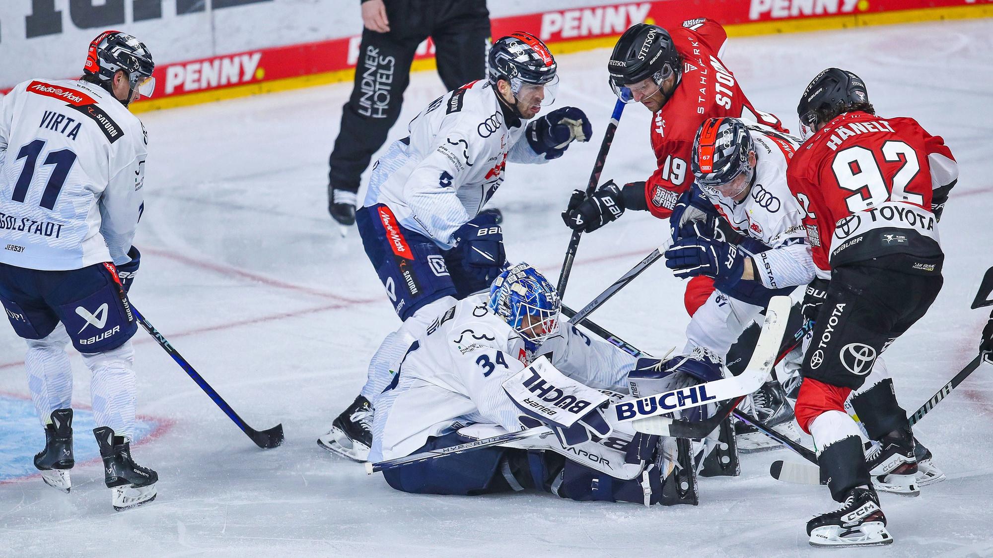 Torhüter Michael Garteig ERC Ingolstadt verteidigt sitzend auf dem Eis das Tor gegen Frederik Storm Kölner Haie und Haakon Hänelt Kölner Haie.