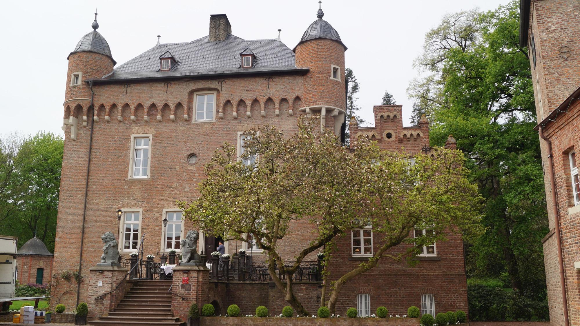 Zu sehen ist ein Schloss aus Backstein mit Türmen.