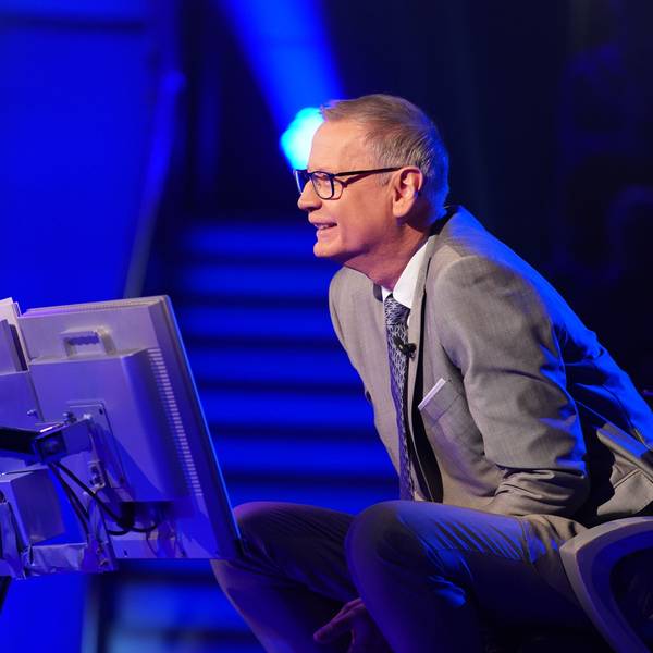 „Wer wird Millionär?“-Moderator Günther Jauch sitzt am Pult der RTL-Quizshow und blickt lächelnd zu einem Kandidaten herüber.