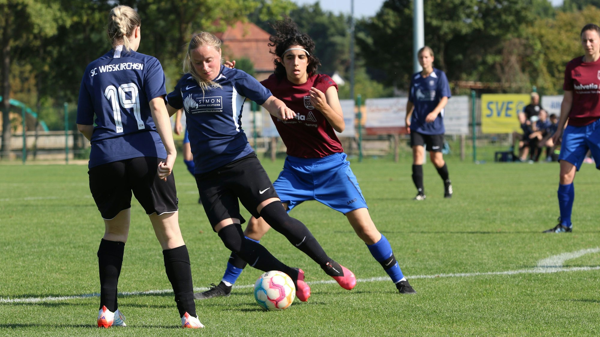 Elen Zimmer schirmt den Ball vor der Gegnerin ab. Eine Mitspielerin schaut zu.
