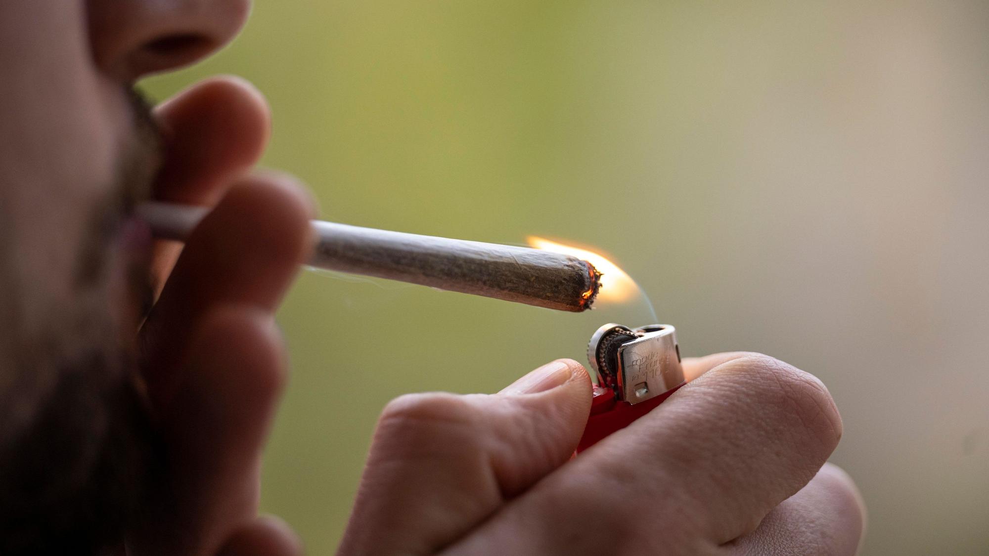 Eine Person zündet sich einen Joint an.