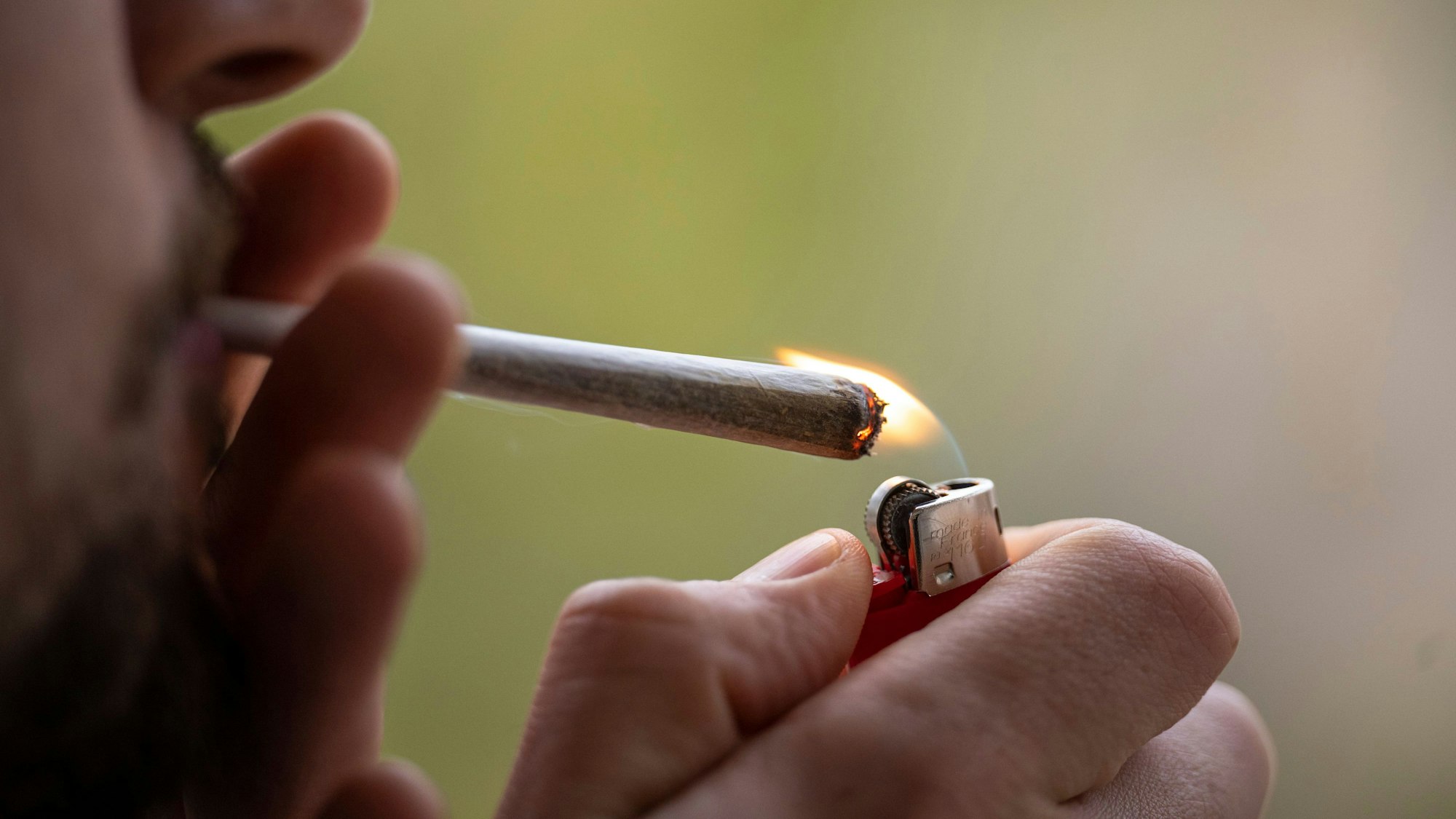 Eine Person zündet sich einen Joint an.
