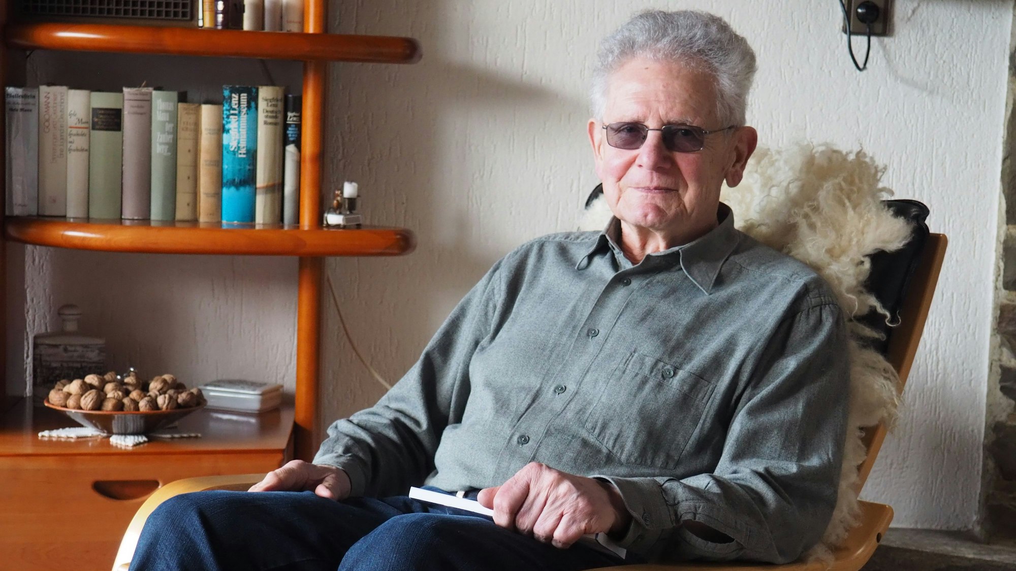 Ein Mann sitzt auf einem Sessel.