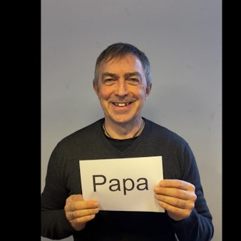 Ralf Gebhardt hält ein Schild vor seiner Brust mit der Aufschrift "Papa".
