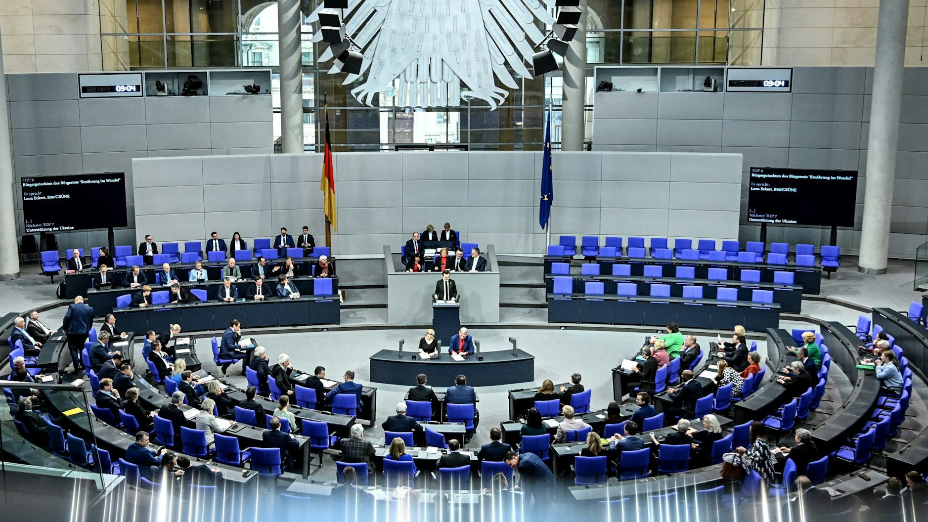 Die Abgeordneten des Bundestags stimmen über die Lieferungen von Taurus-Marschflugkörpern an die Ukraine ab. Mehrere Abgeordnete sitzen auf den blauen Sitzen im Plenum des Bundestags.