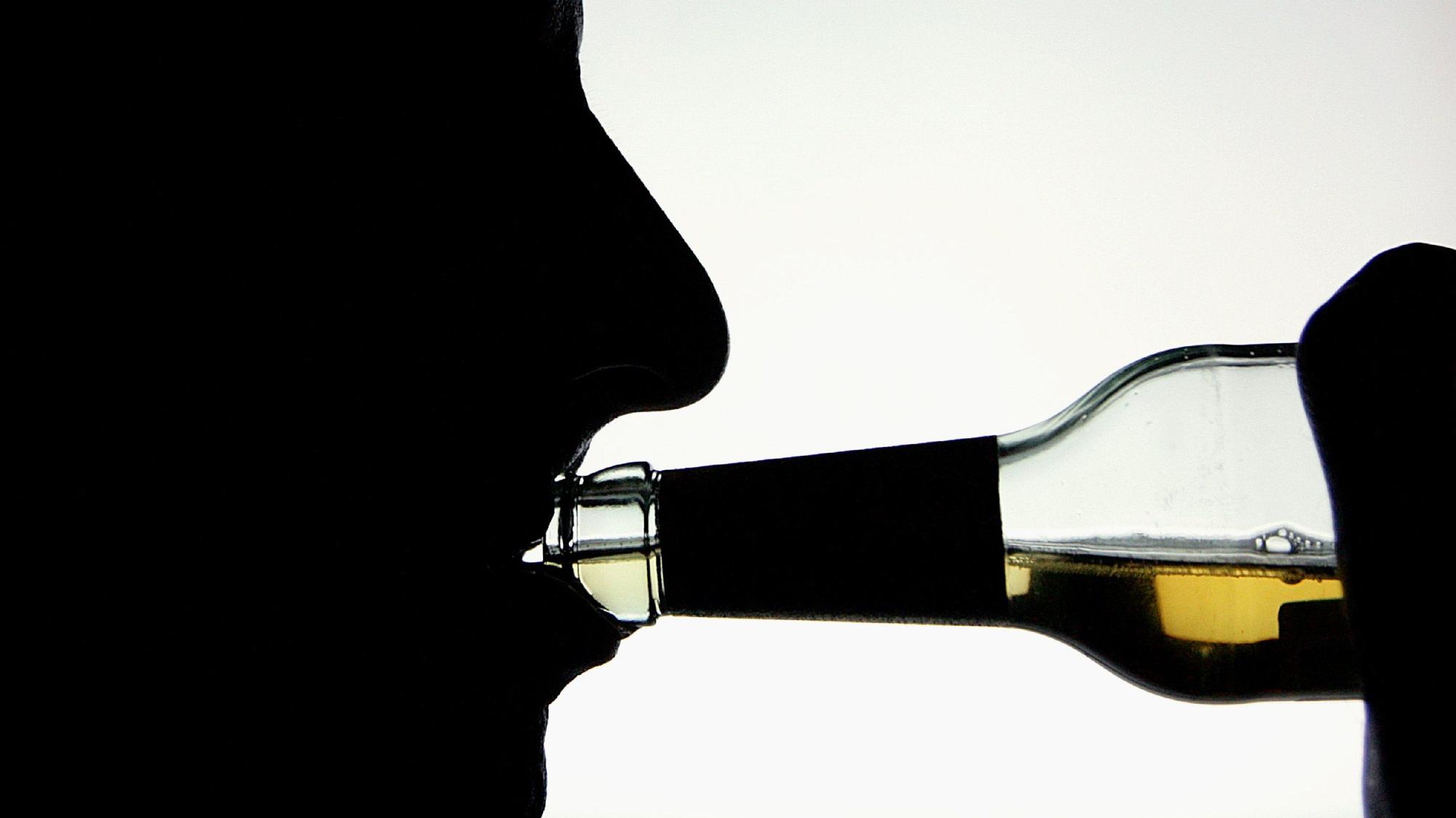 Die Silhouette eines Alkohol trinkenden Mannes