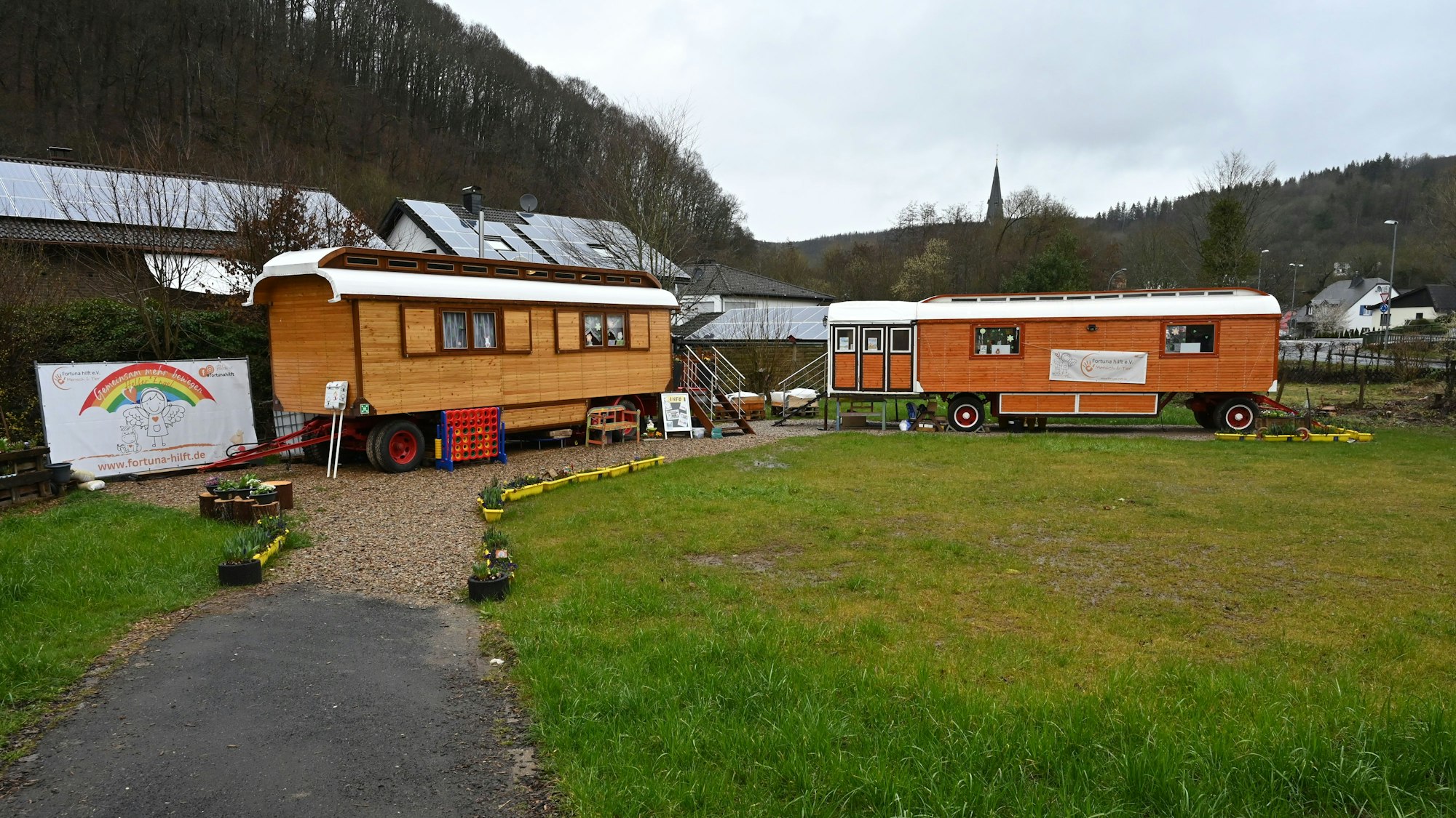 Zwei Zirkuswagen stehen auf einer Wiese in Gemünd. Darin wird der Malzirkus für Kinder aus von der Flutkatastrophe betroffenen Familien angeboten.