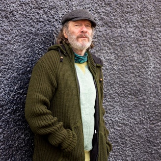 Gerd Köster steht an eine Wand gelehnt.