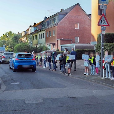 Kinder protestieren gegen das Verkehrschaos vor ihrer Schule.