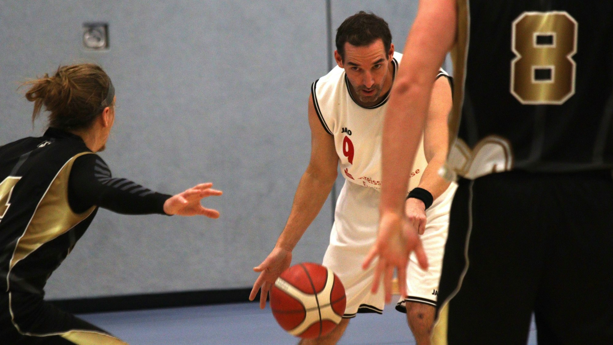 Thorsten Winkelnkemper dribbelt den Ball und wird von zwei Gegenspielern bedrängt.