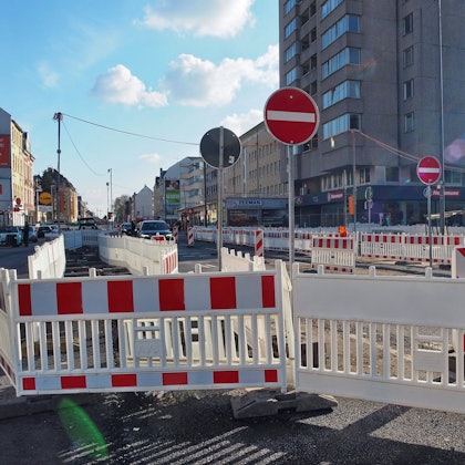Lauter rot-weiße Absperrungen stehen an einer Straße.