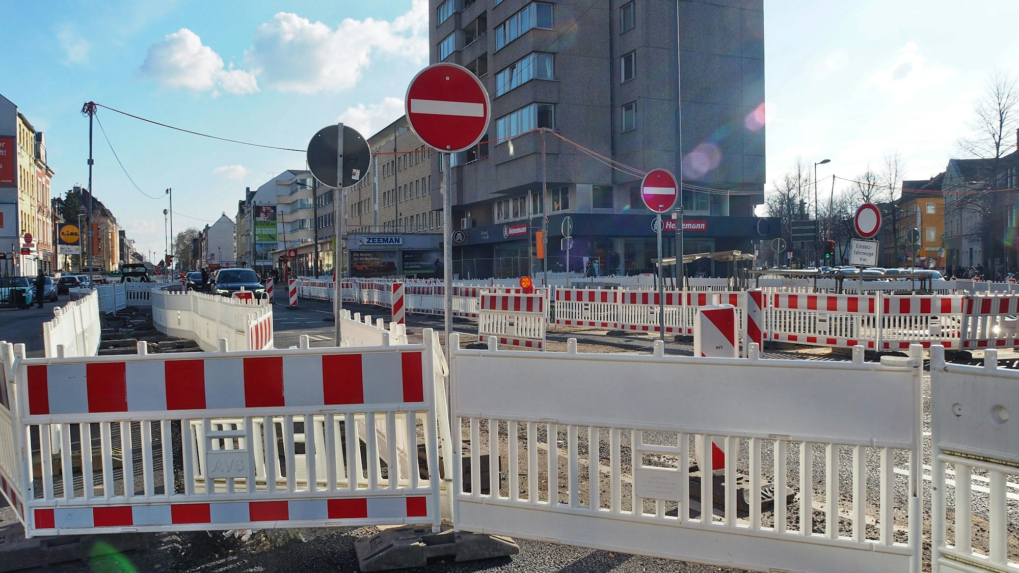 Lauter rot-weiße Absperrungen stehen an einer Straße.