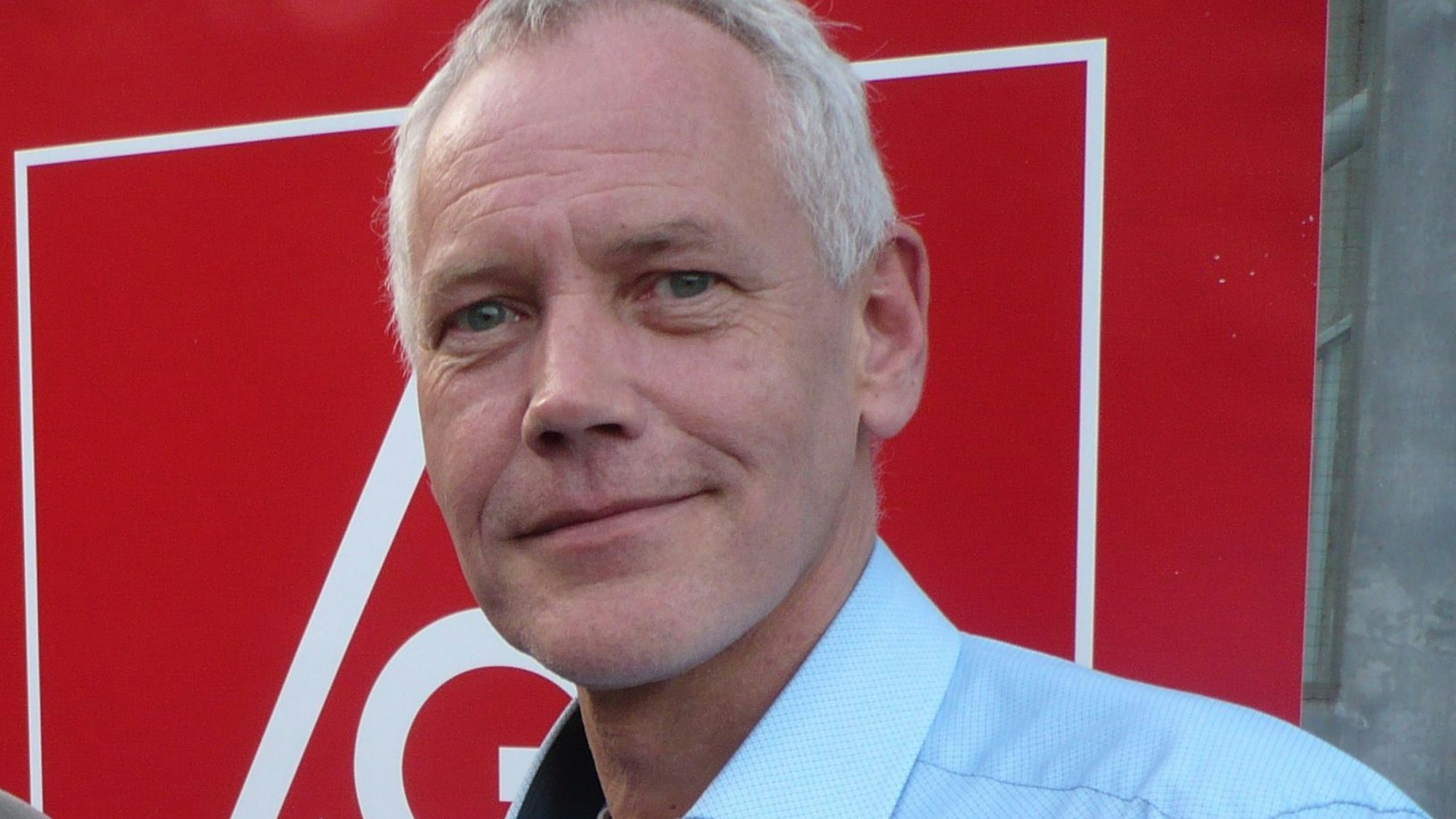 Porträt eines Mannes vor dem Symbol der IG Metall