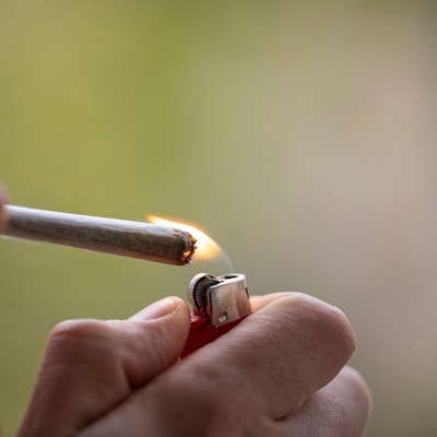 Ein Mann zündet sich einen Joint an.
