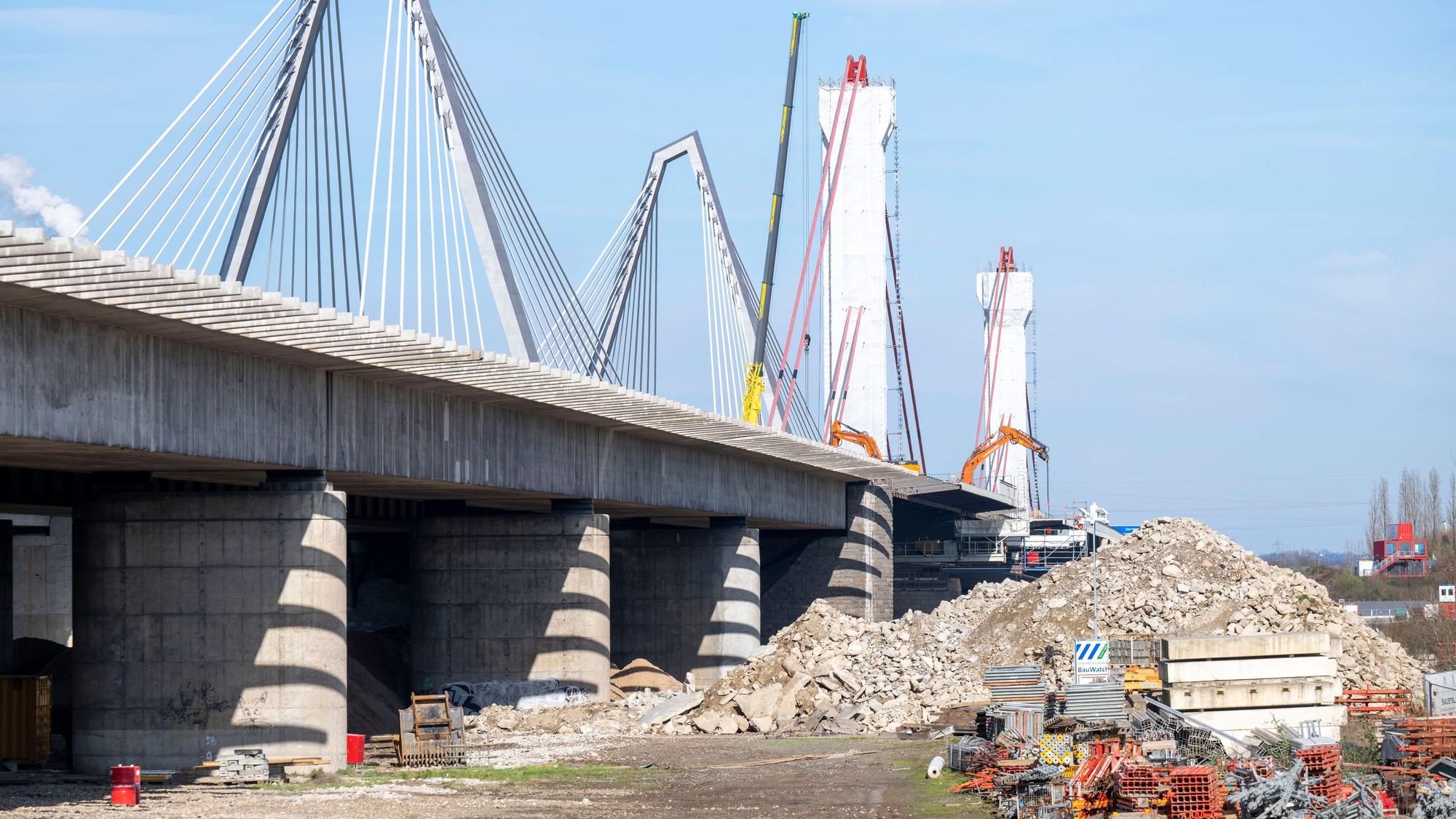 Blick auf die Leverkusener Brücke, ein großer Schuttberg türmt sich neben dem stillgelegten alten Brückenteil.