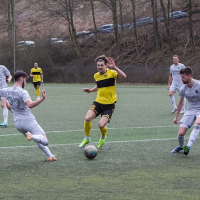 Hohkeppels Enzo Wirtz läuft mit dem Ball am Fuß durch zwei Gegenspieler.