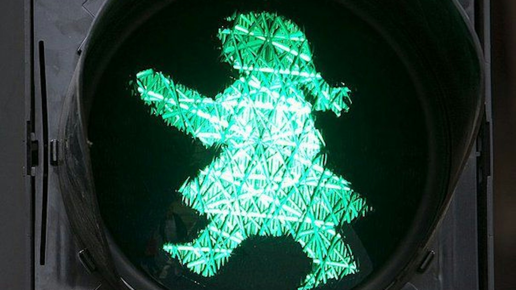 Eine Ampelfrau als Lichtzeichen mit einem stilisierten Haarzopf und einem Rock.