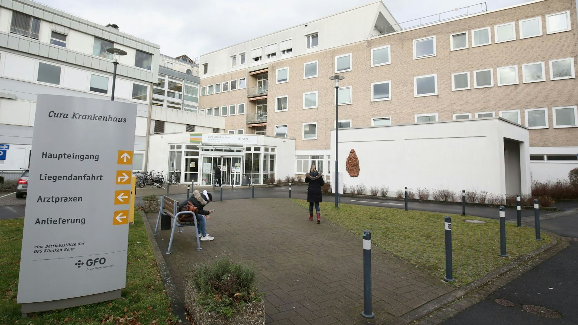 Der Eingangsbereich des Bad Honnefer Cura-Krankenhauses. Auf einer Bank sitzt eine Person.