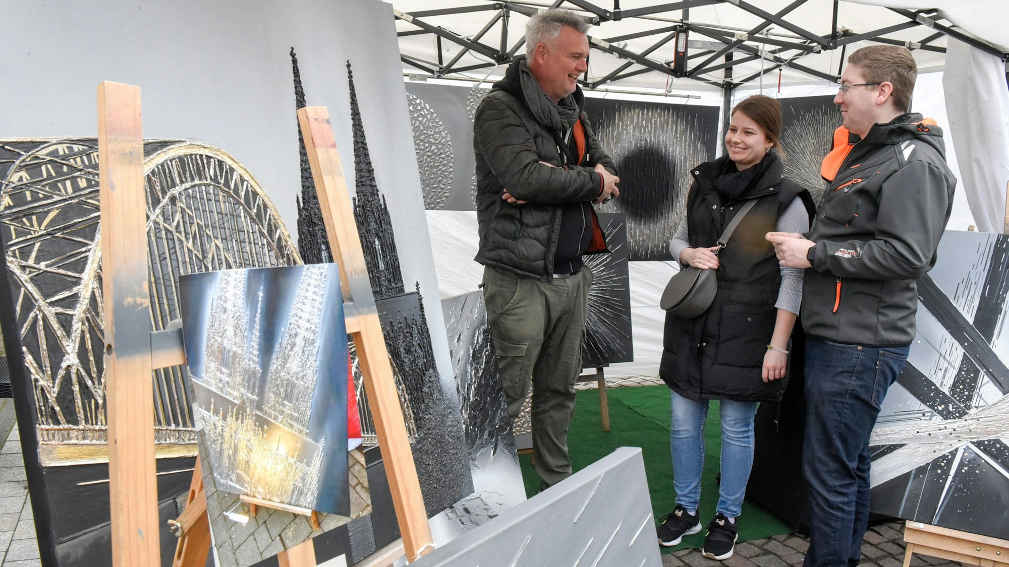 Auf dem Bild ist ein Künstler zu sehen, der seine Werke verkauft.