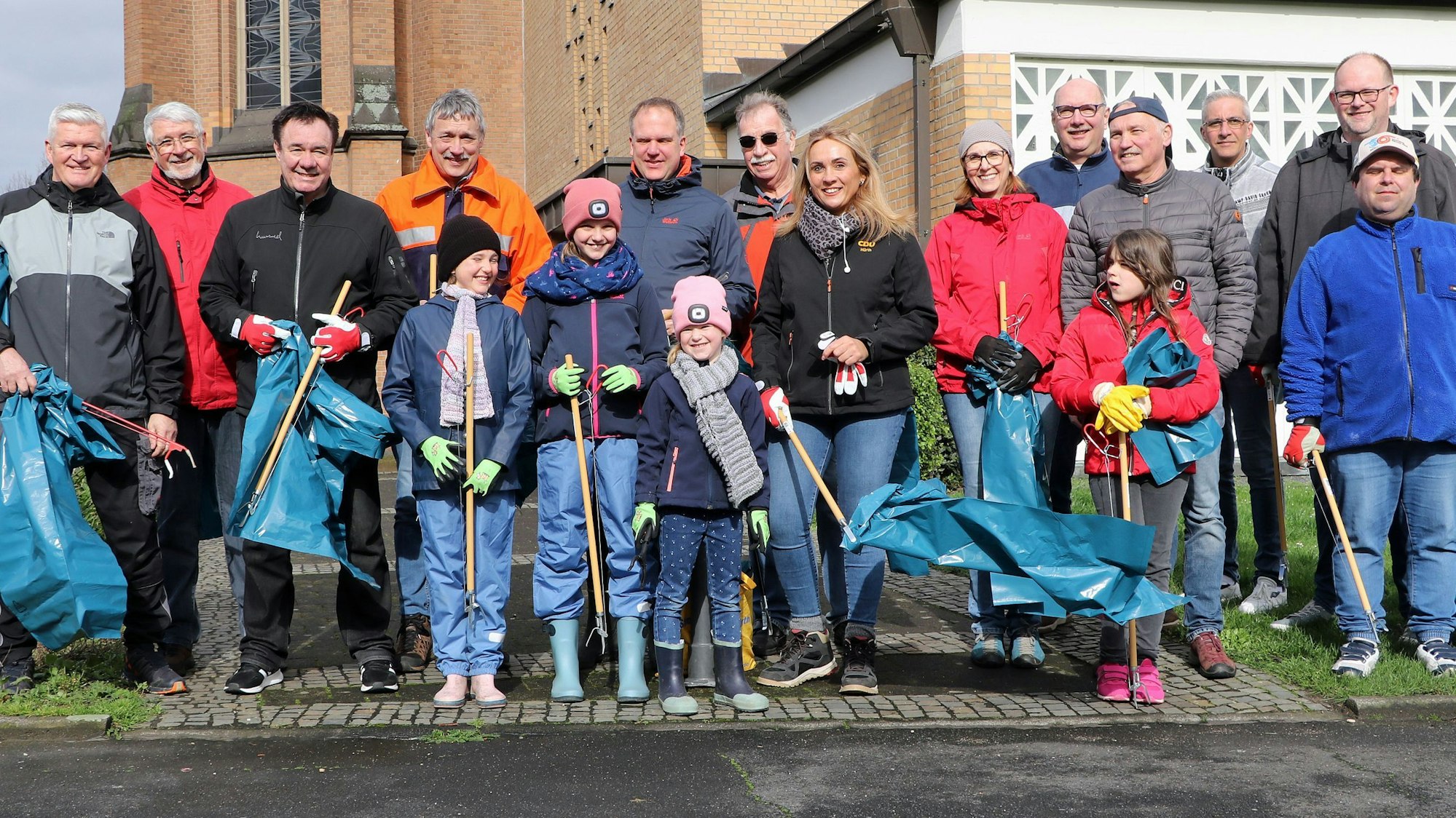 Auf dem Bild sind Helfer zu sehen, die Müll sammeln wollen.