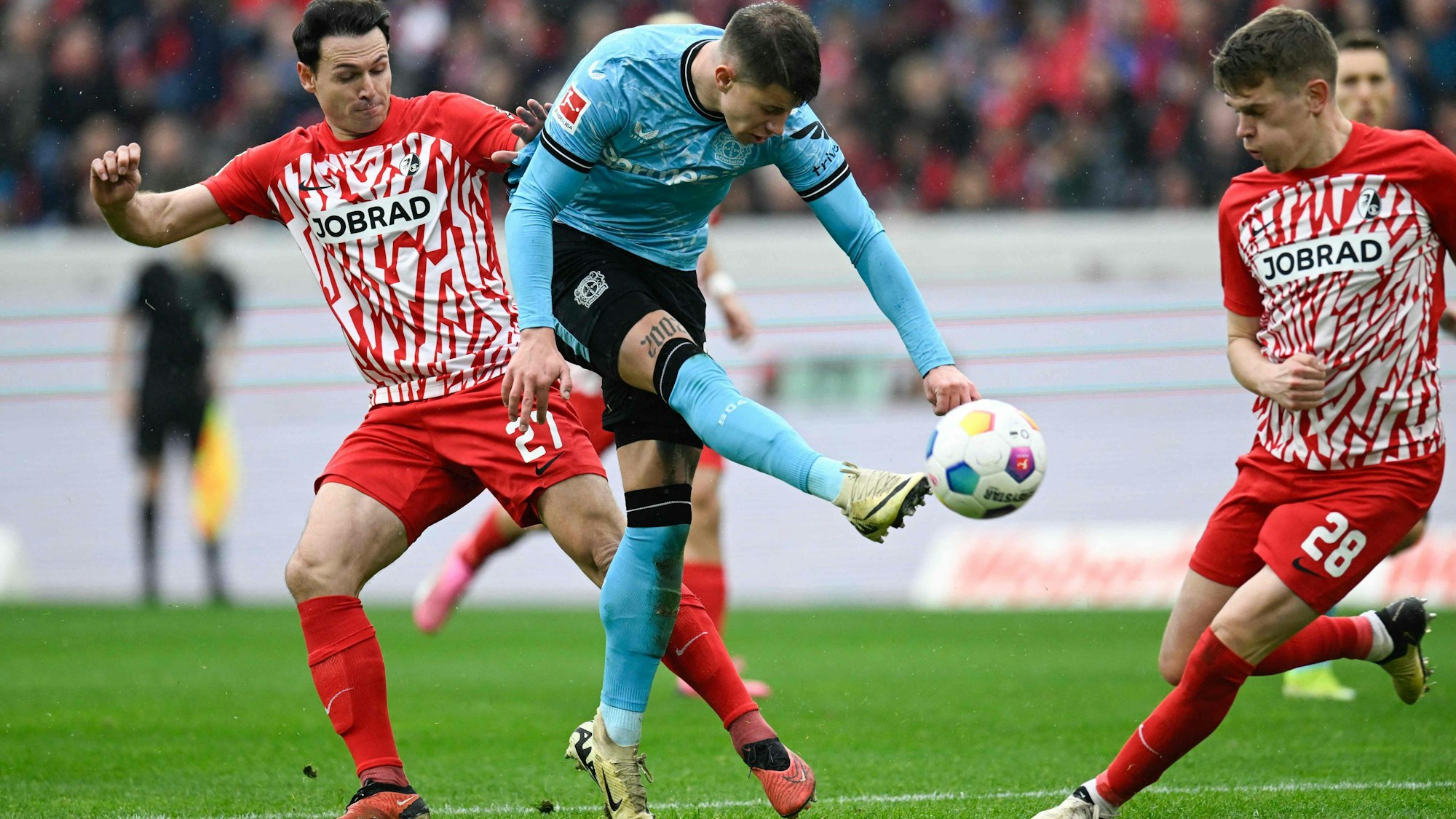 Freiburgs Nicolas Hoefler, Bayer Leverkusens Adam Hlozek and Freiburgs Matthias Ginter