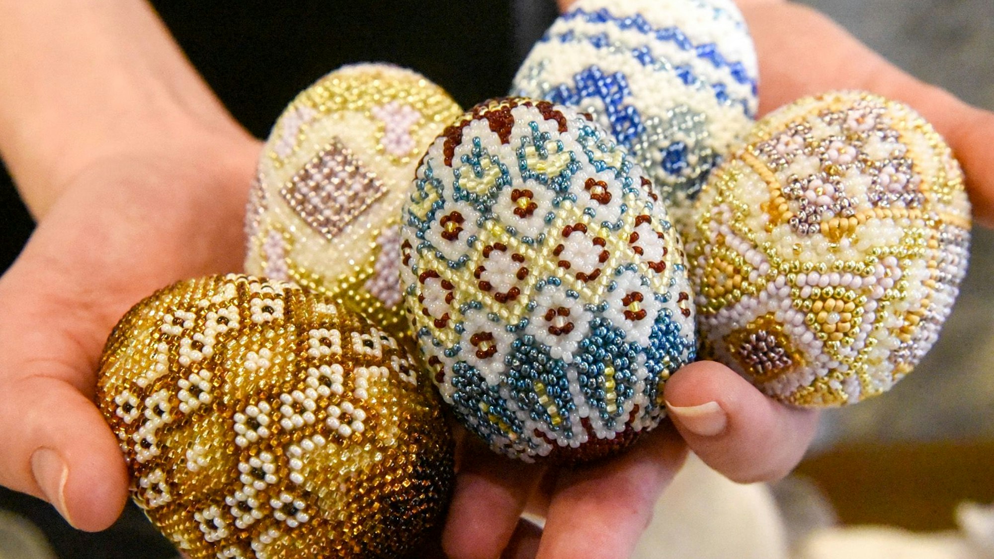 Auf dem Bild sind mit Perlen geschmückte Ostereier zu sehen.