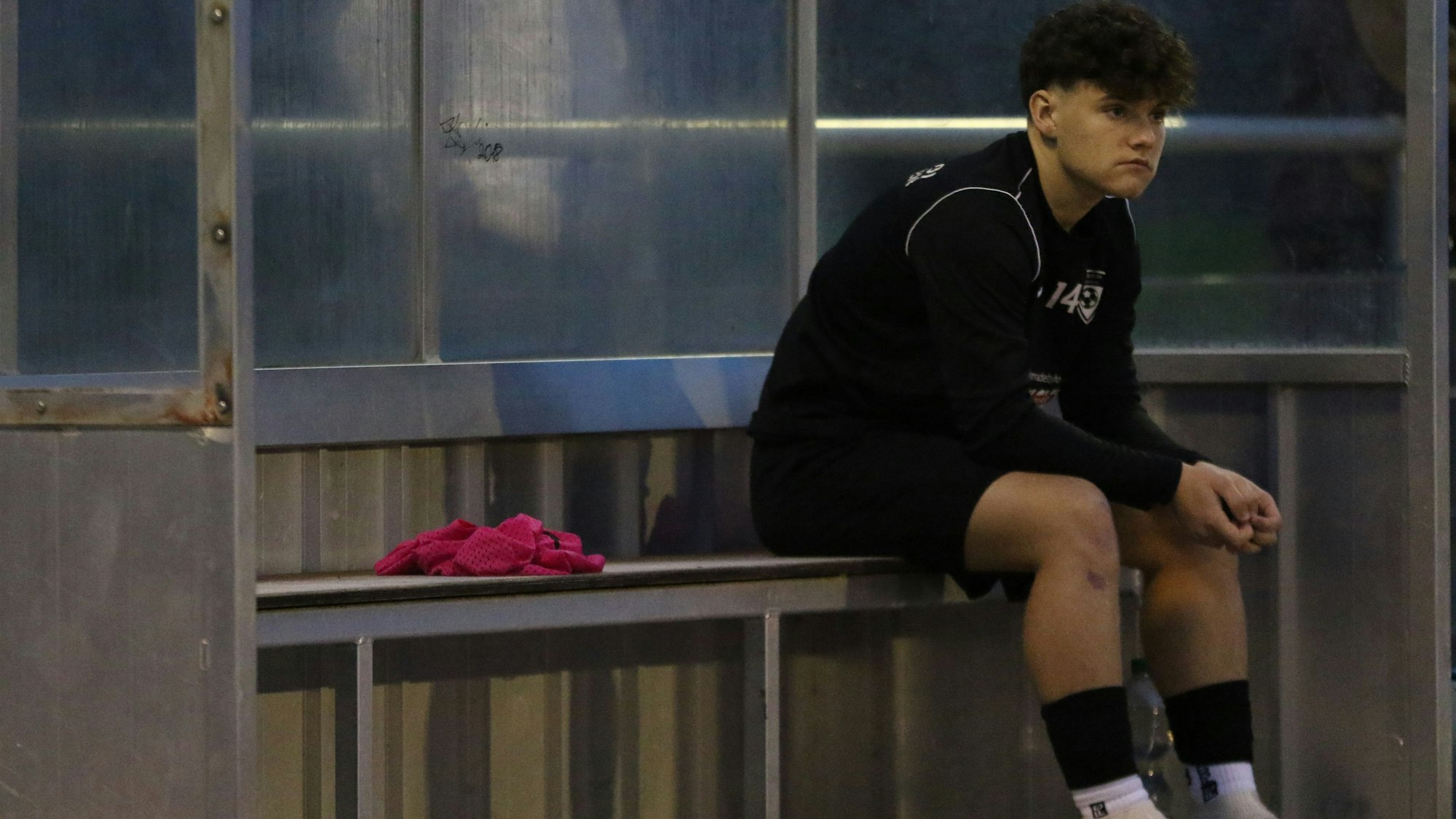 Philip Urbanek sitzt als Ersatzmann auf der Spielerbank der JSG Erft 01 Euskirchen, bevor er in die Partie kommt.