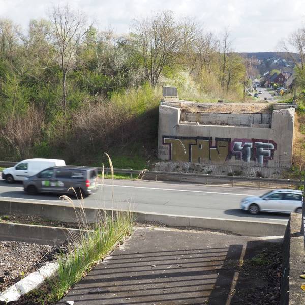 Zu sehen ist eine Autobahn, von der Brücke, die einmal darüber verlief, stehen nur noch die Pfeiler.