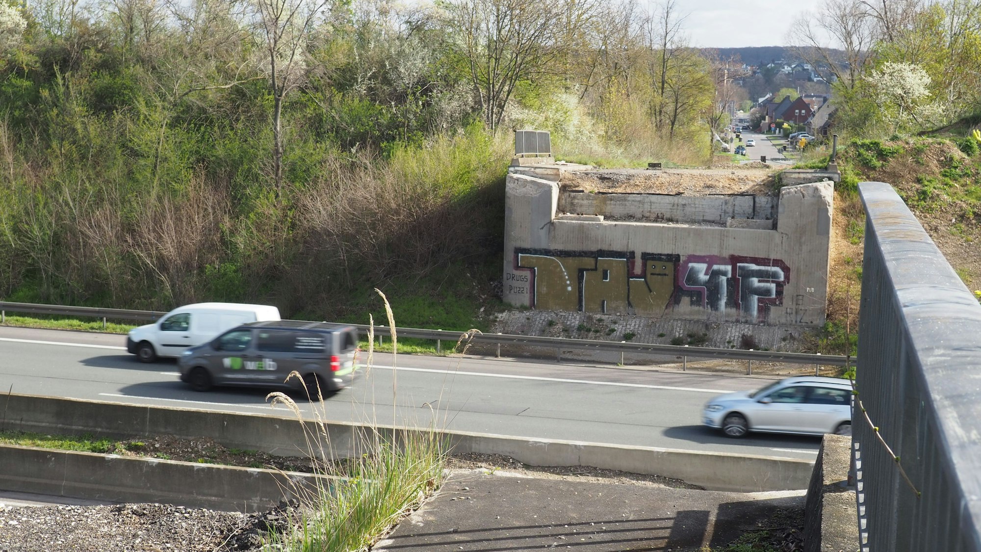 Zu sehen ist eine Autobahn, von der Brücke, die einmal darüber verlief, stehen nur noch die Pfeiler.