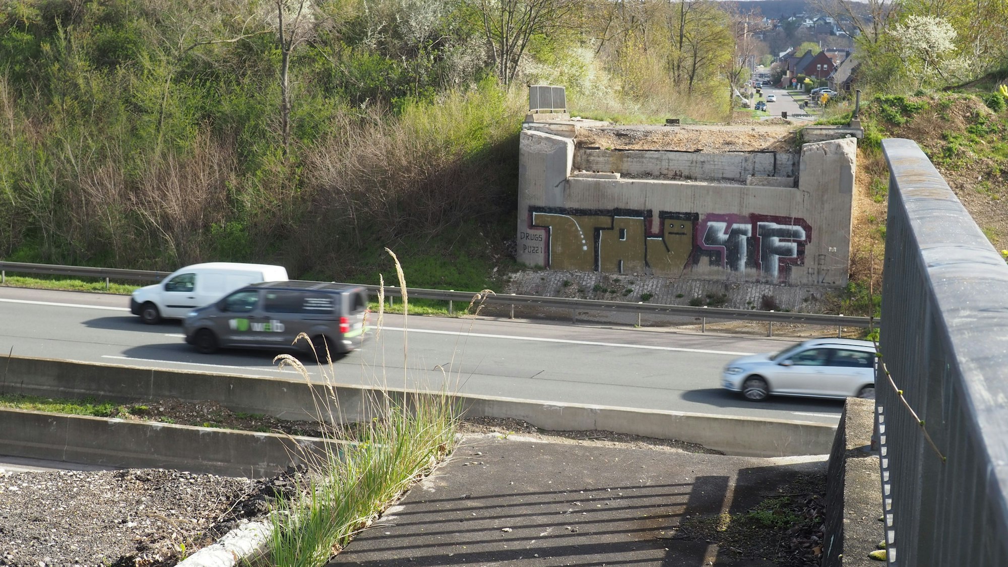 Zu sehen ist eine Autobahn, von der Brücke, die einmal darüber verlief, stehen nur noch die Pfeiler.