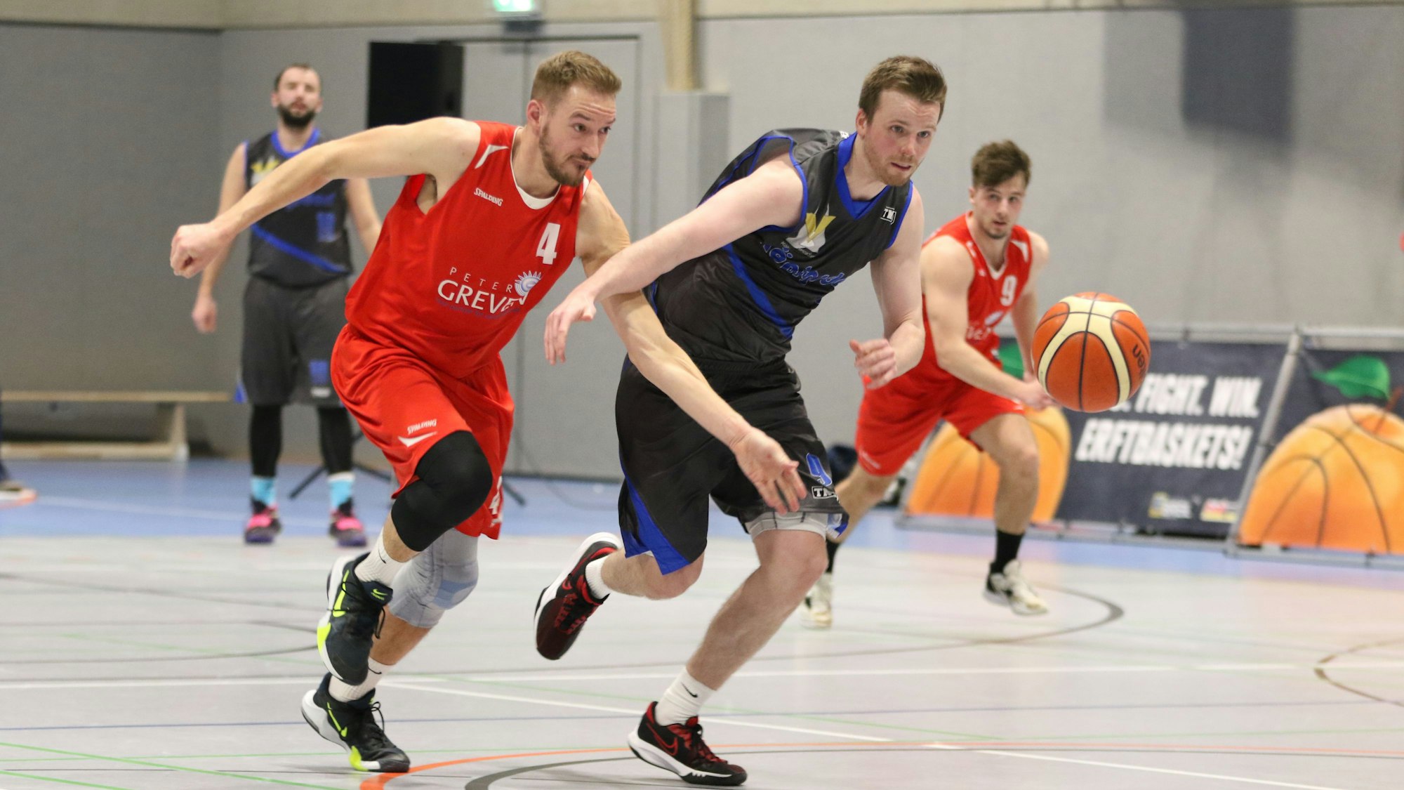 Das Bild zeigt Jan Winkelnkemper im Laufduell mit einem Gegenspieler. Beide haben den Ball im Blick, dem sie folgen.